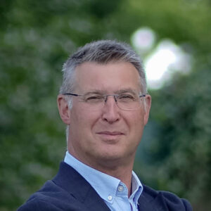 Eine Person mit Brille vor unscharfem Hintergrund.