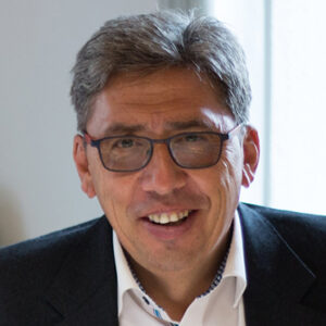 Ein Mann mit Brille lächelt in die Kamera.