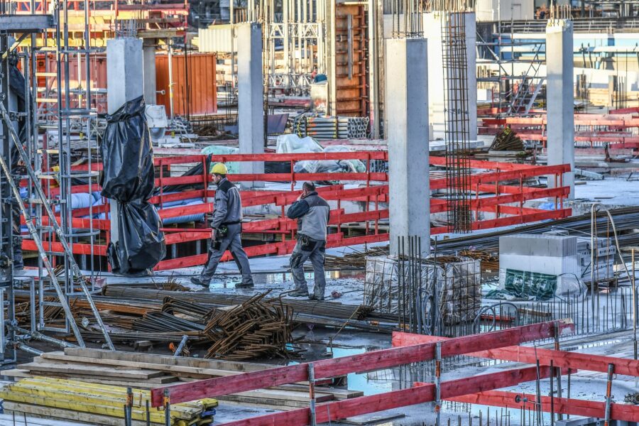 Bauarbeiter laufen im Rohbau einer Baustelle.