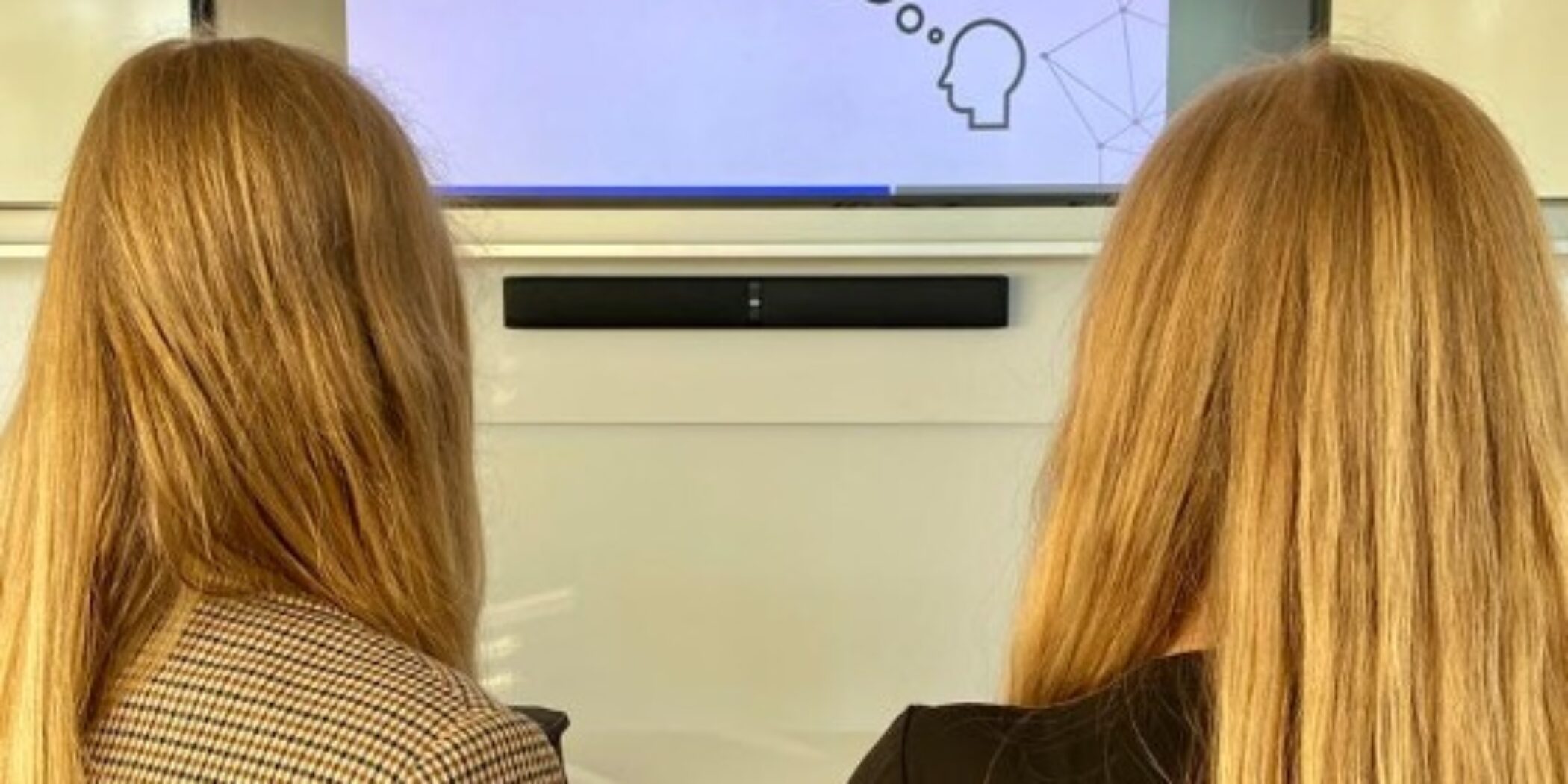 Zwei Studentinnen schauen auf eine Powerpoint-Präsentation
