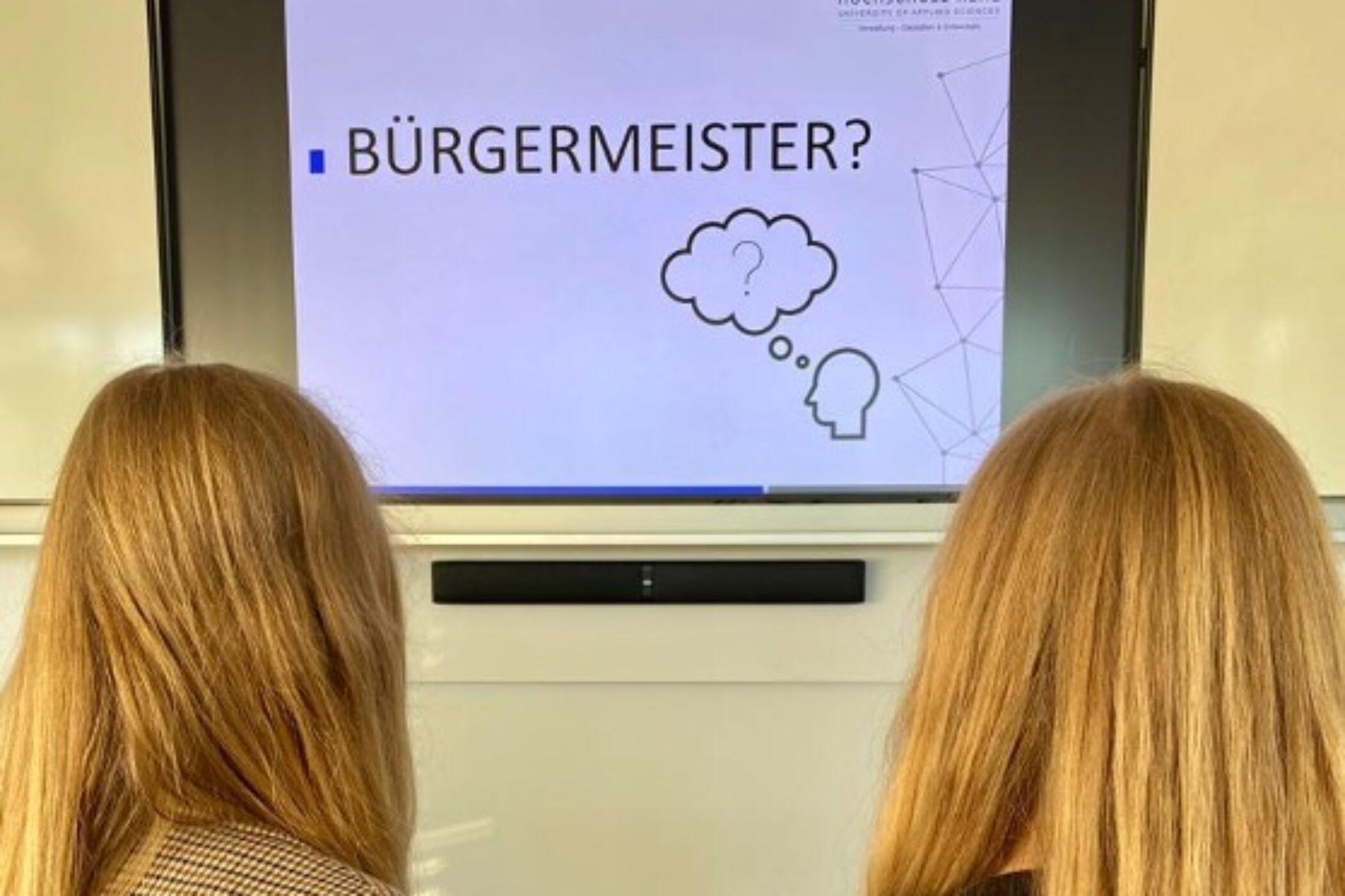 Zwei Studentinnen schauen auf eine Powerpoint-Präsentation