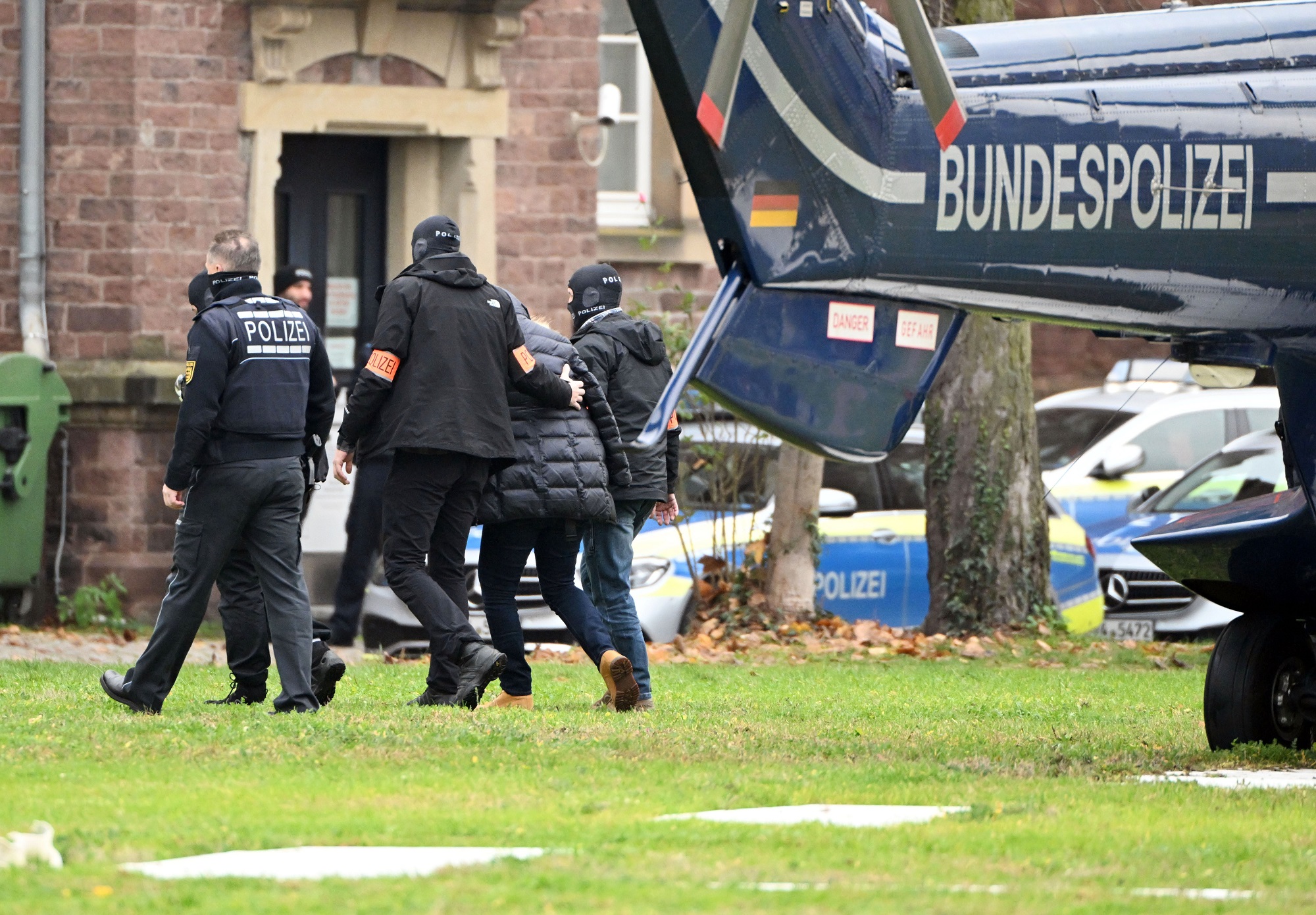 Eine Person wird von Polizisten aus einem Hubschrauber gebracht.