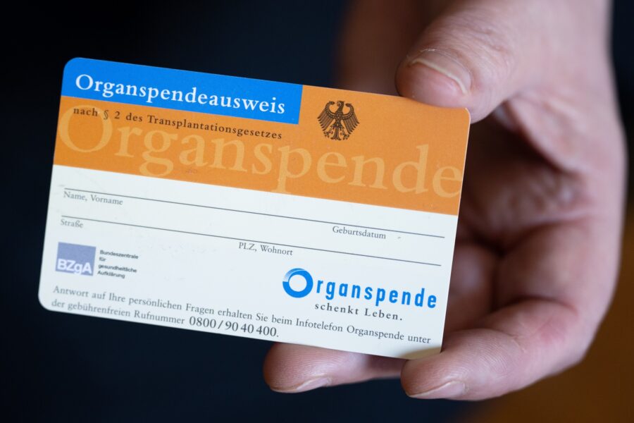 Eine Frau hält einen Organspendeausweis in ihren Händen