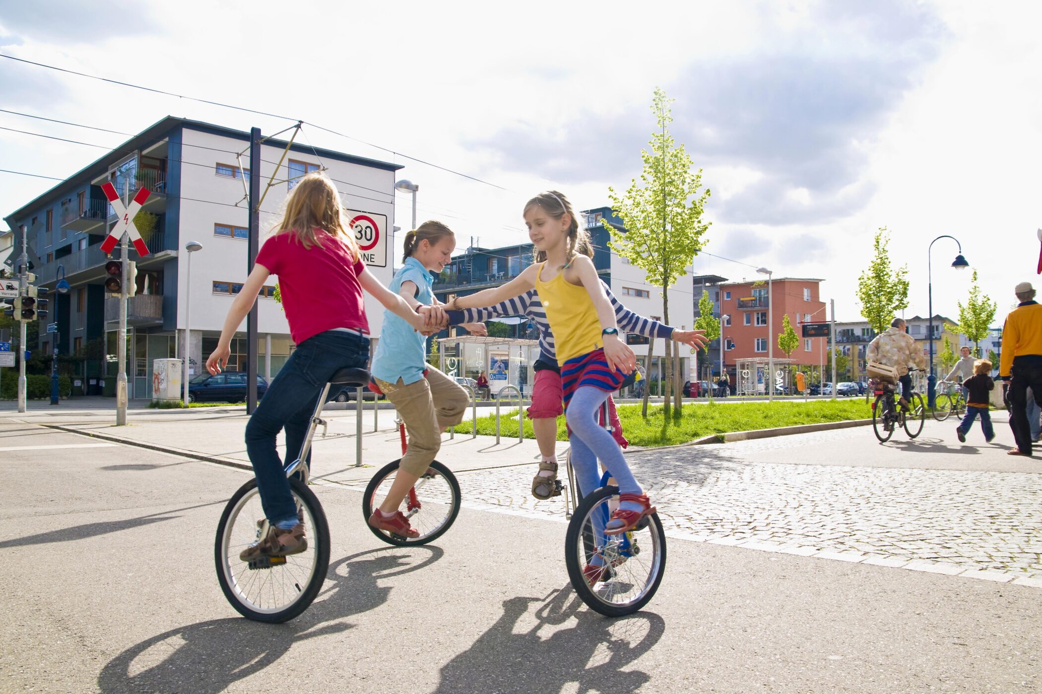 Auf Einrad fahrende Kinder in einer Spielstraße im Vauban-Viertel in Freiburg im Breisgau