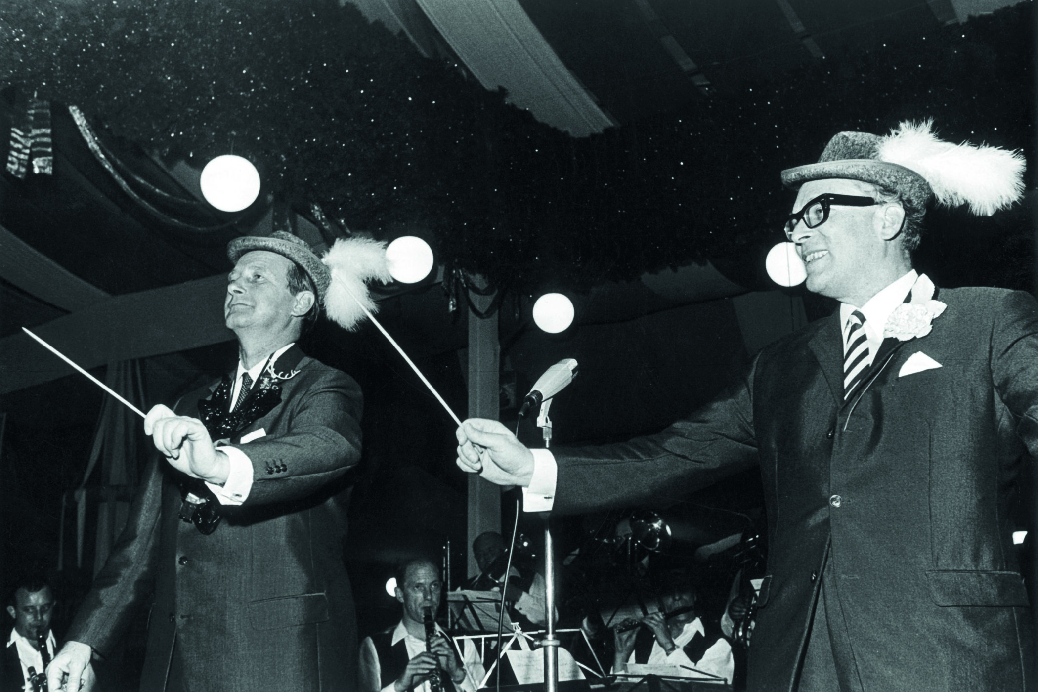 Ministerpräsident Dr. Hans Filbinger (l) und sein Stellvertreter, Innenminister Walter Krause (SPD), mit jeweils einem Taktstock beim gemeinsamen Dirigieren einer Trachtenkapelle im Volksfestzelt auf den Cannstatter Wasen in Stuttgart am 03.10.1967