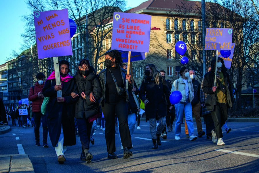 Teilnehmerinnen einer Demo am Internationalen Frauentag mit Schildern auf Spanisch und Deutsch