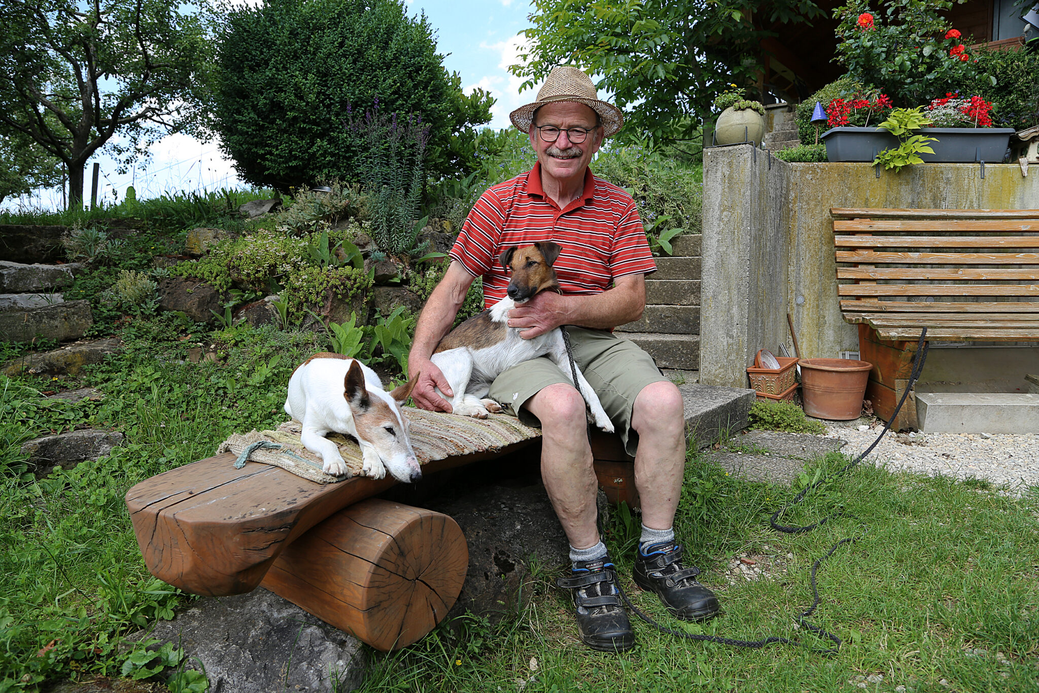 Karl Ederle auf einer Bank mit zwei Hunden