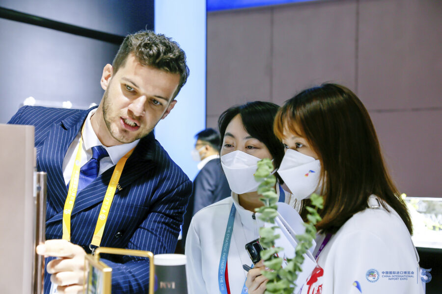 Ein Mann berät chinesisches Frauen bei einer Messe