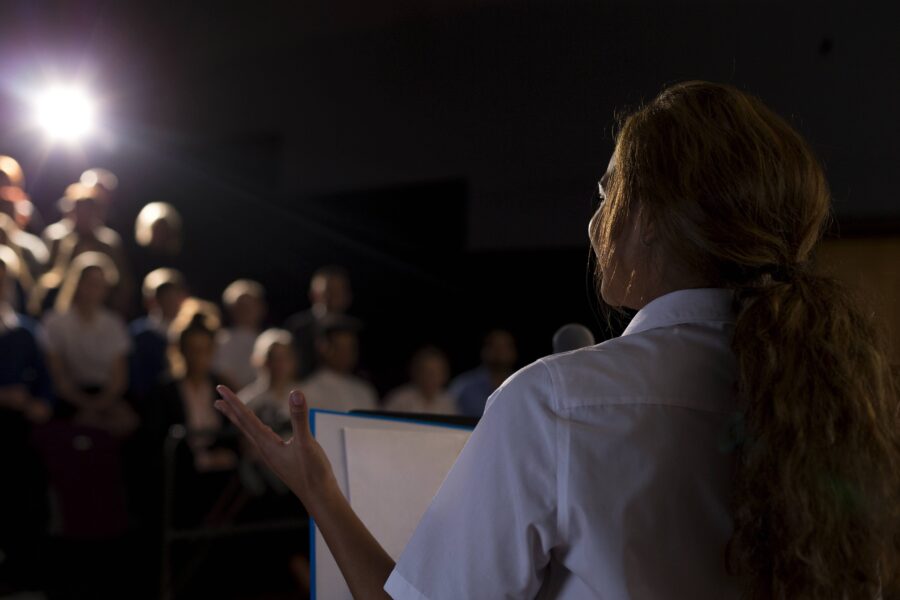 Frau hält eine Rede vor Publikum