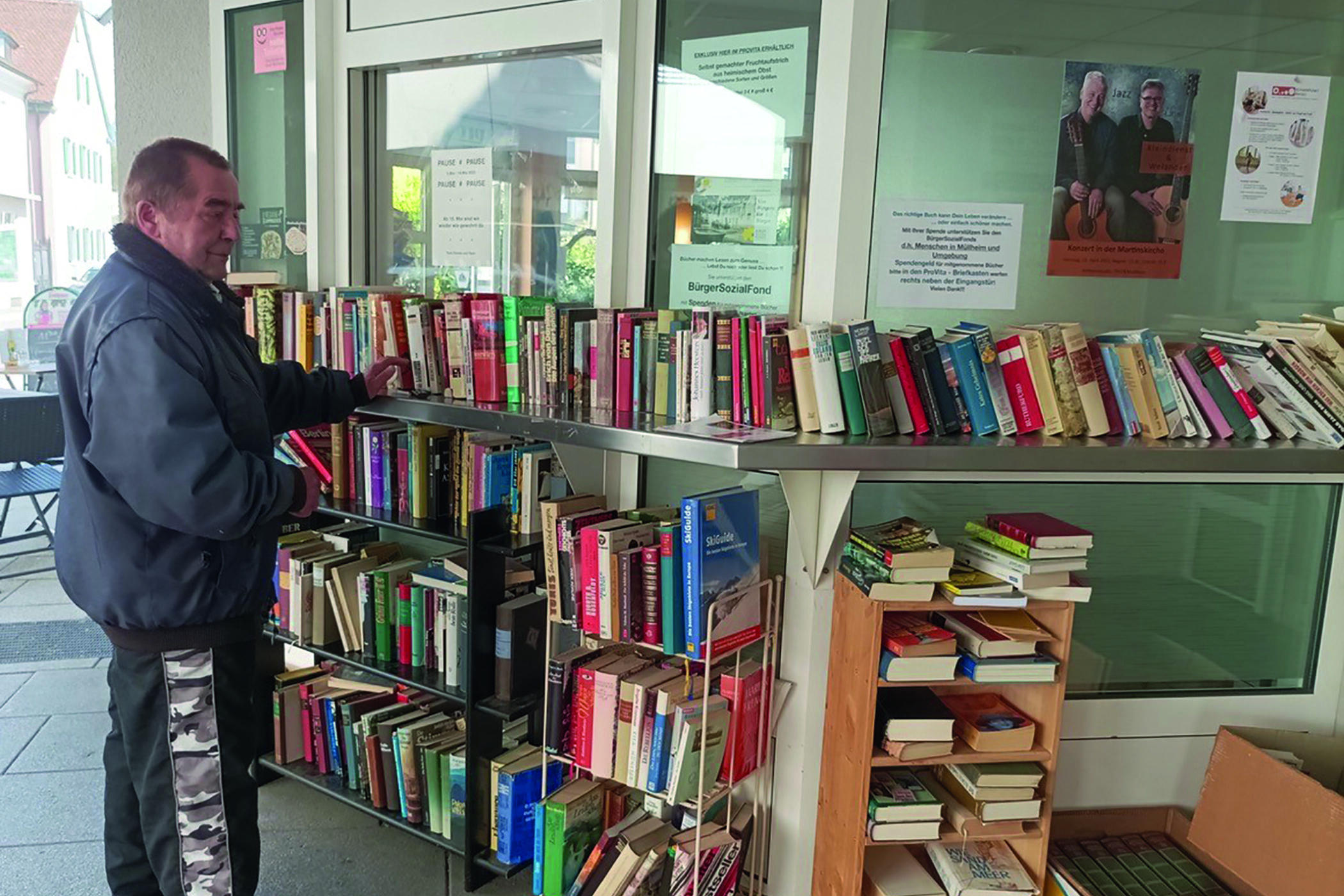 Mann steht vor einem Bücherschrank
