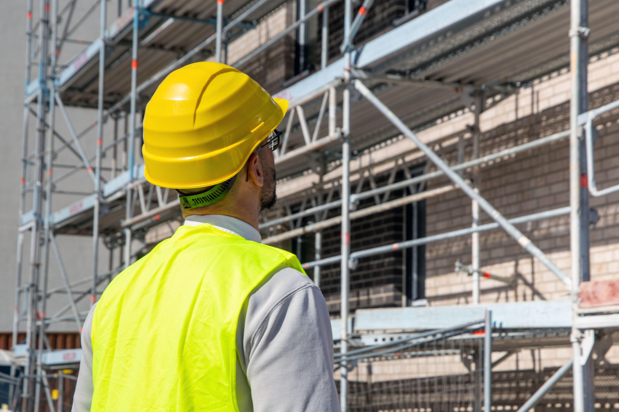 Architekt vor einem Mehrfamilienhaus im Bau