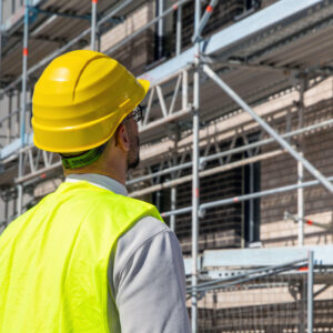 Architekt vor einem Mehrfamilienhaus im Bau