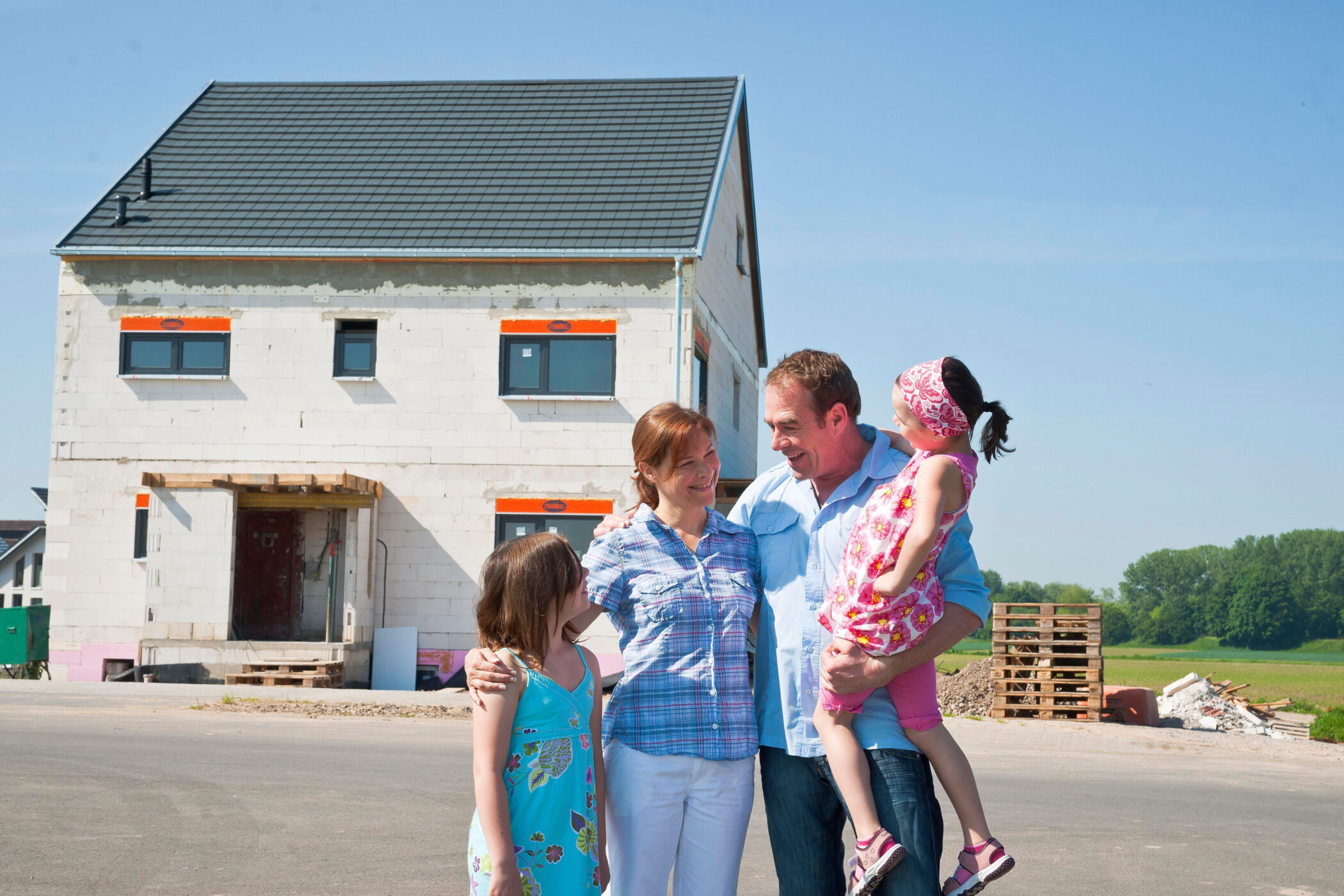 Familie steht vor Haus