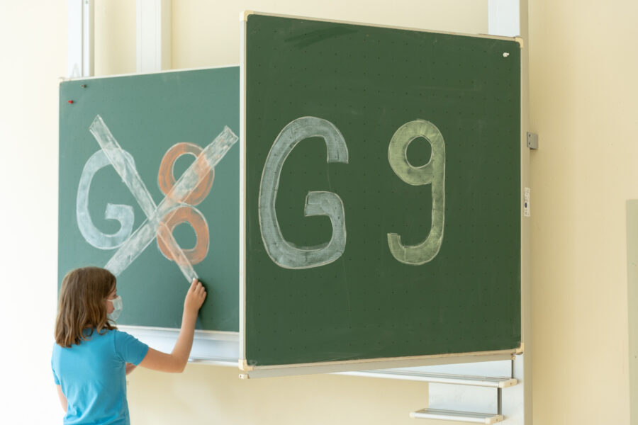Eine Schülerin einer Schule hat «G8» an einer Tafel durchgestrichen, «G9» daneben bleibt unberührt.