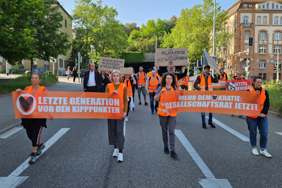 Aktivistinnen und Unterstützer der Gruppierung Letzte Generation demonstrieren in Stuttgart mit Transparenten. Nach der Razzia gegen einige ihrer Mitglieder setzt die Klima-Protestgruppe Letzte Generation vorerst wohl auf Demonstrationen anstatt auf Straßenblockaden. Die Aktivisten blockierten seit Anfang 2022 immer wieder große Straßen in vielen Städten und fordern mehr Maßnahmen für den Klimaschutz.