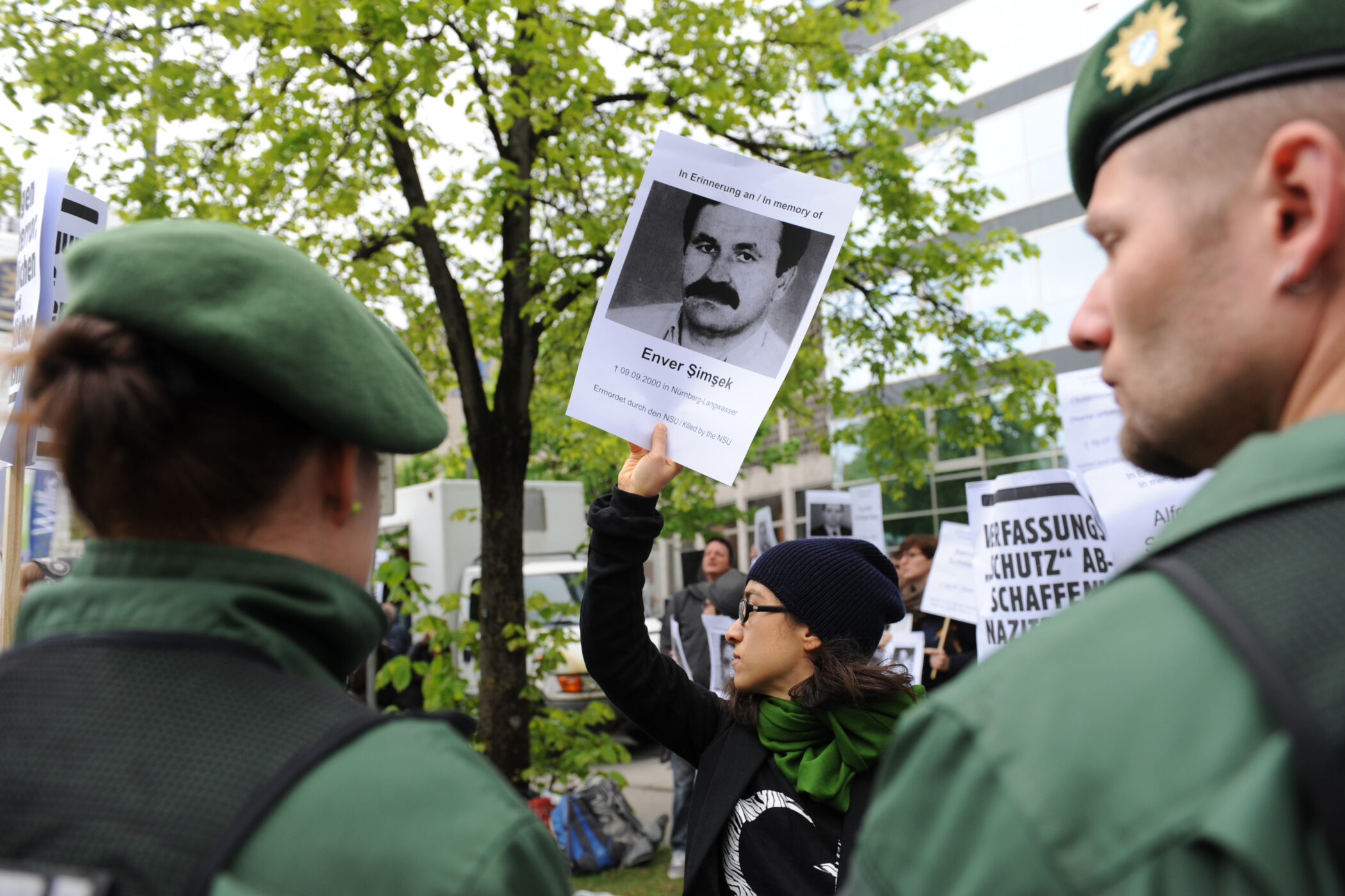 Eine Demonstrantin hält 2013 vor dem Gerichtsgebäude in München ein Foto des ersten NSU-Mordopfers Enver Simsek in die Höhe.