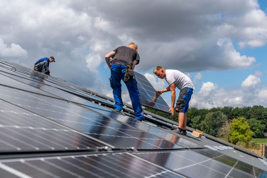 Montage von Solarmodulen auf das Dach einer Scheune, eines landwirtschaftlichen Betriebs, über 210 Photovoltaik Module werden auf dem Dach installiert