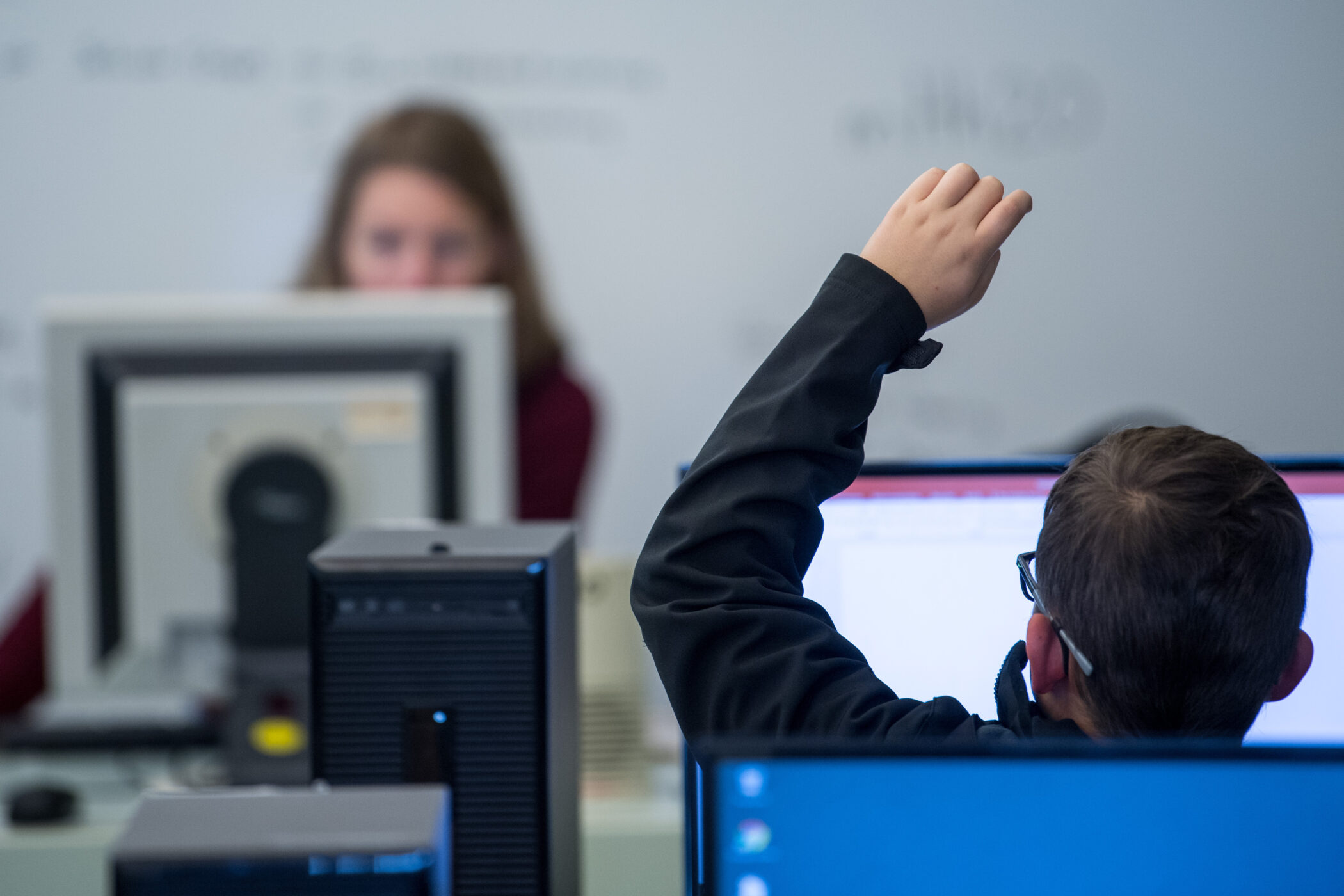 Ein Schüler meldet sich an einer Schule während dem IT-Unterricht.