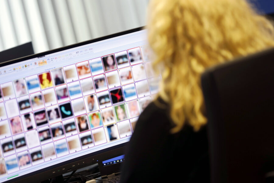 Person vor Monitor mit vielen kleinen, unscharfen Bildern.