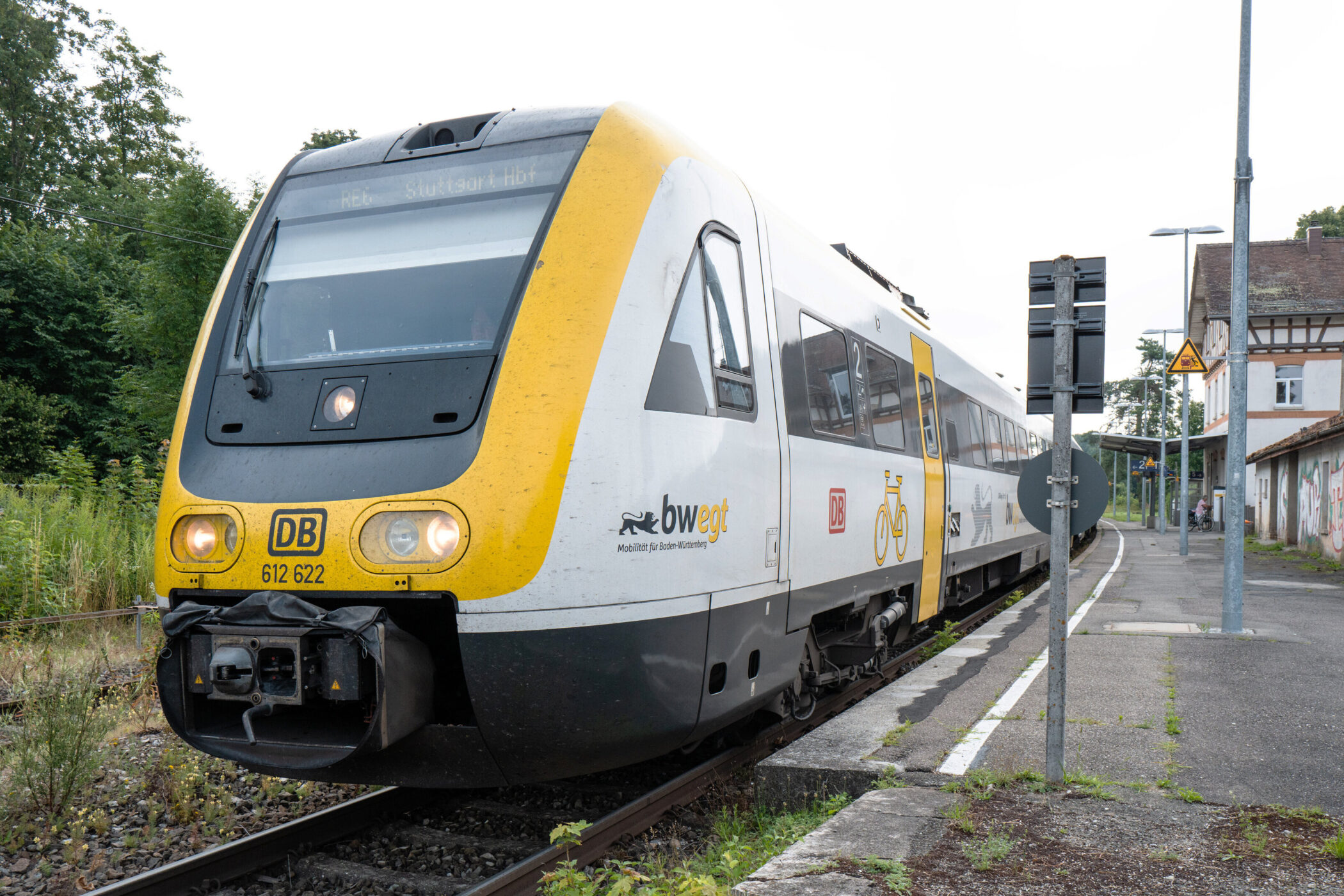 Zug der Deutschen Bahn am Bahnsteig, mit gelbem und weißem Design.