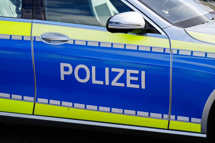Blau-gelbes Polizeiauto mit Schriftzug "POLIZEI" auf der Tür.