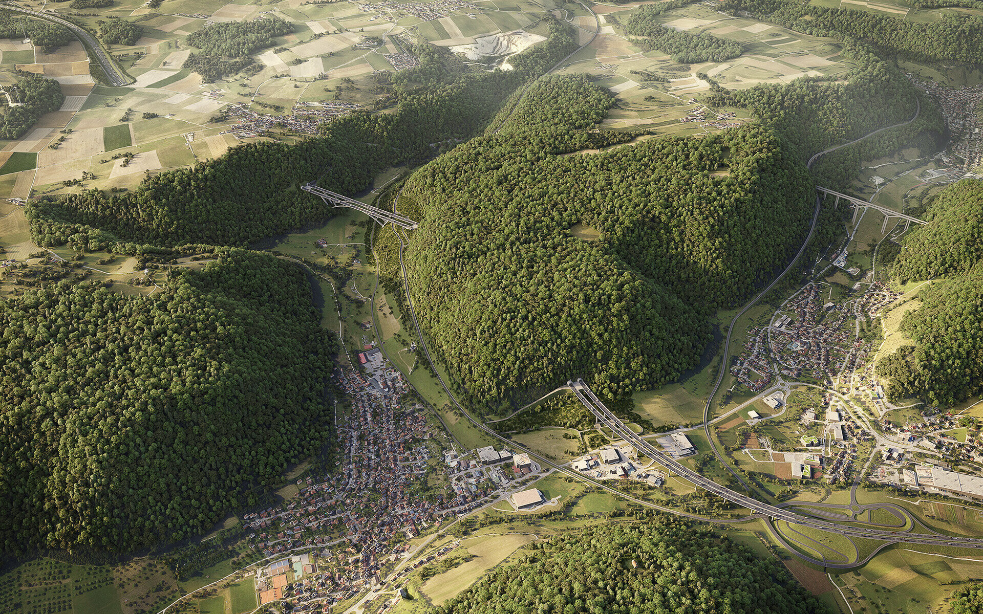Luftaufnahme einer hügeligen Landschaft mit Wäldern, Straßen und Siedlungen.