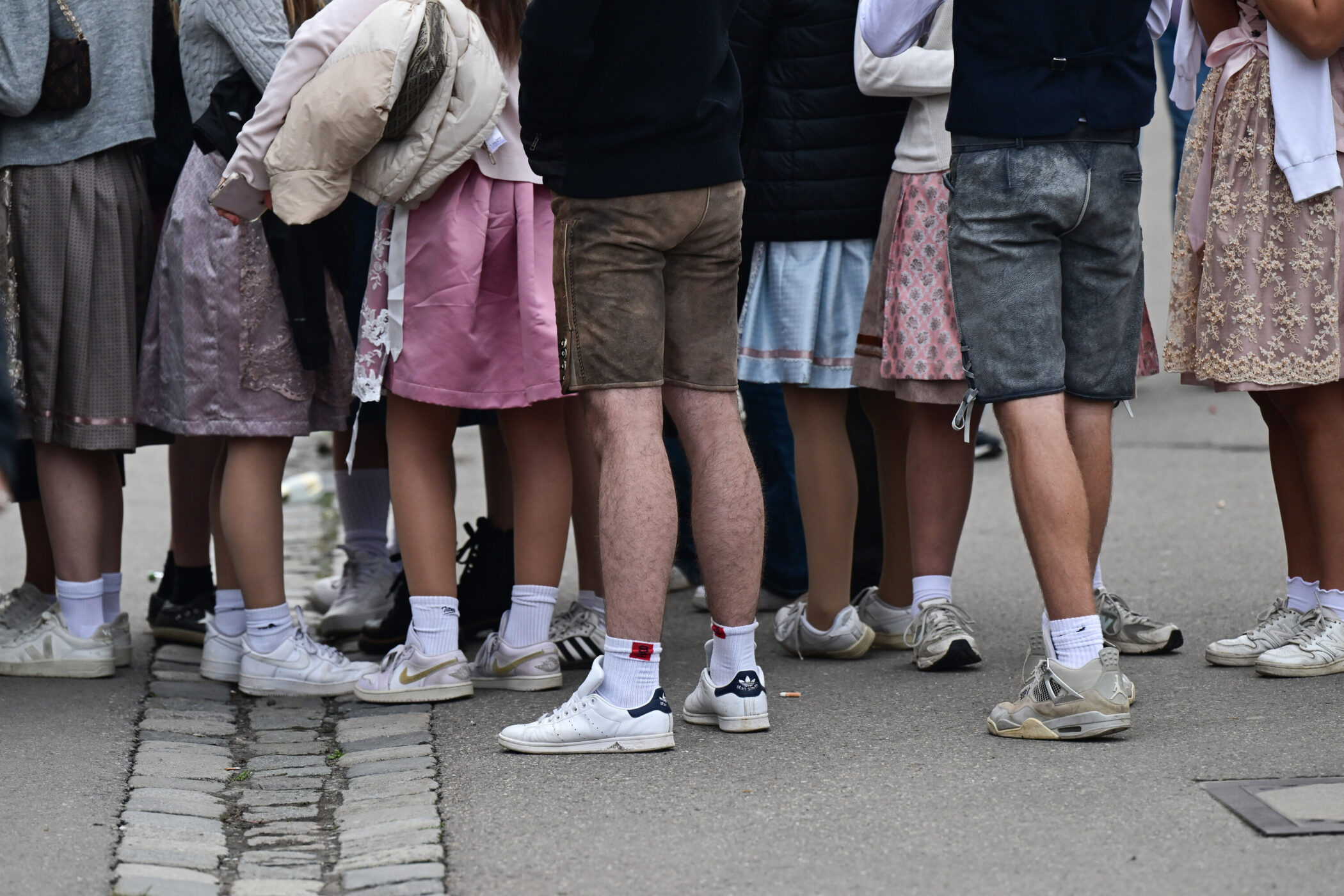 Mehrere Personen in Trachtenkleidung, Fokus auf Beine und Schuhe.