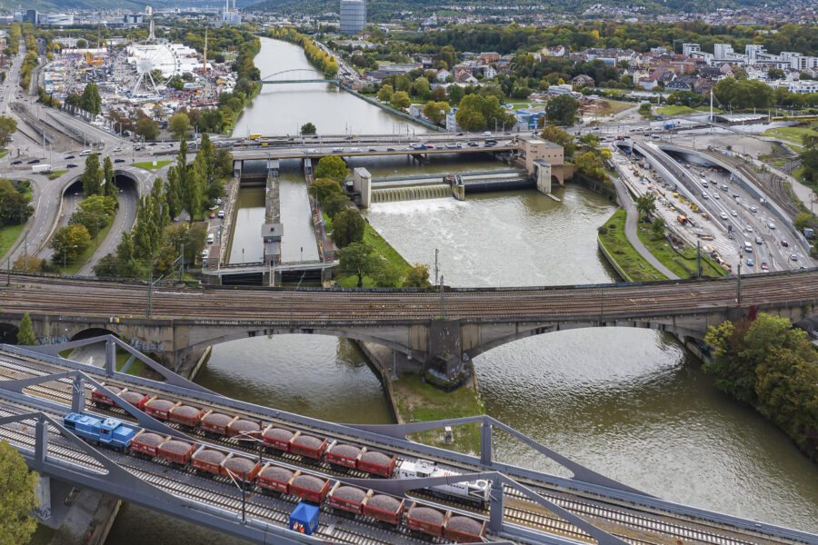 Fluss mit Brücken, Zug und Autos, Stadt im Hintergrund, Riesenrad links.