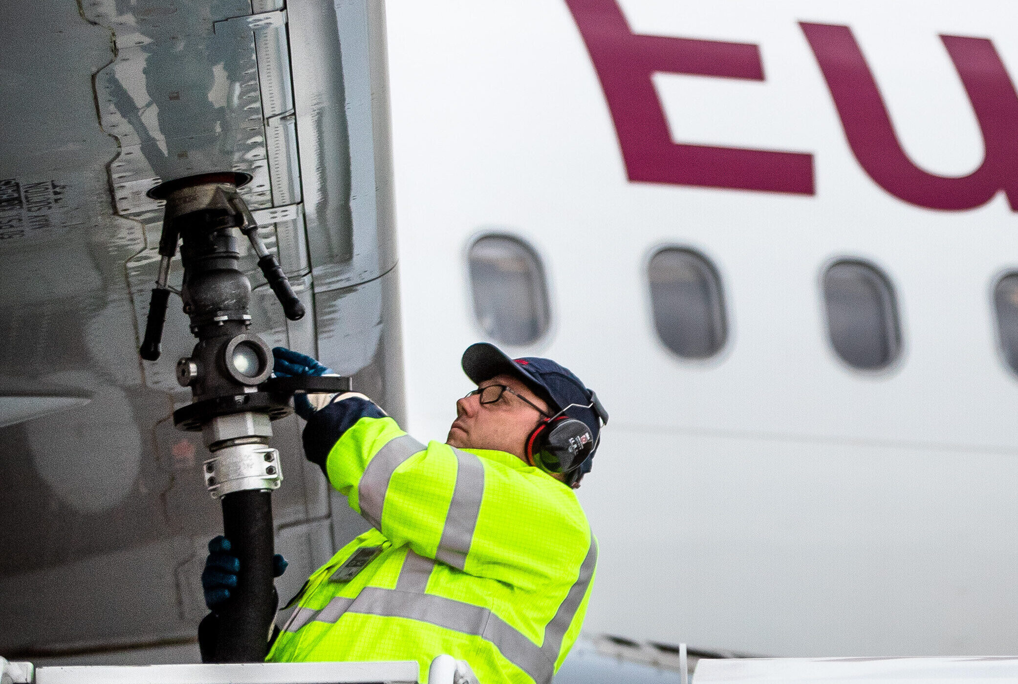 Person in gelber Weste betankt Flugzeug. Text: "Tragkraft 180 kg oder 2 Personen".