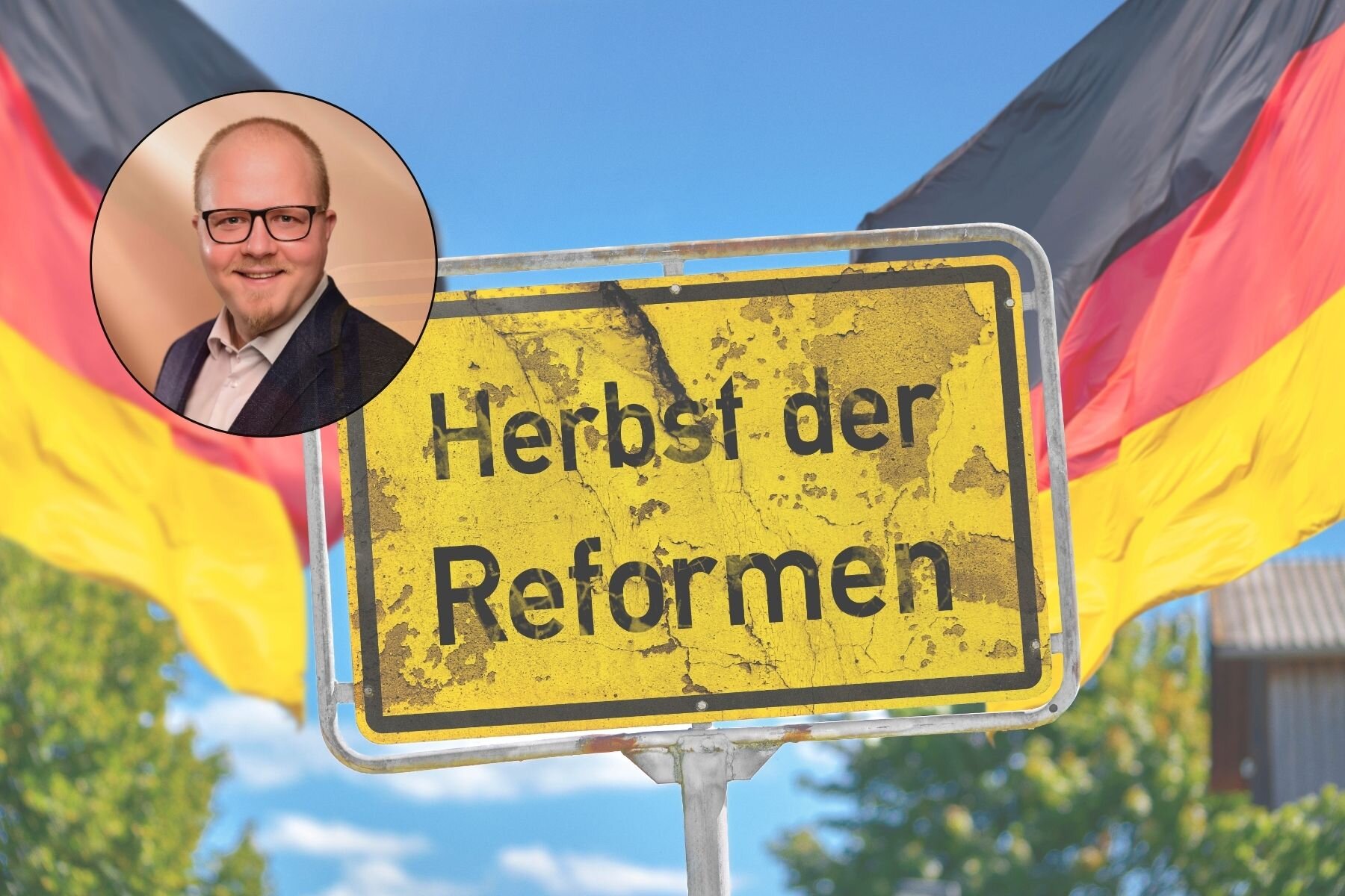 Gelbes Schild mit Text "Herbst der Reformen", deutsche Flagge im Hintergrund.