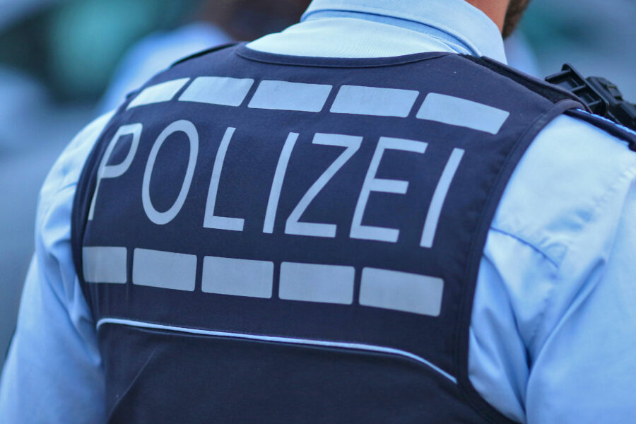 Rückansicht einer Person in Polizeiuniform mit der Aufschrift "POLIZEI".