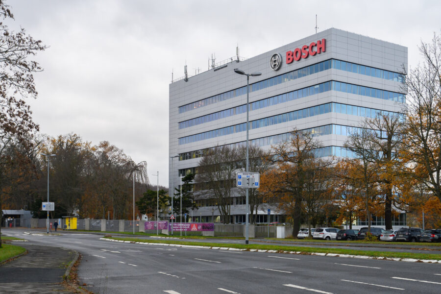 Mehrstöckiges Gebäude mit Bosch-Logo, davor Straße und Bäume.
