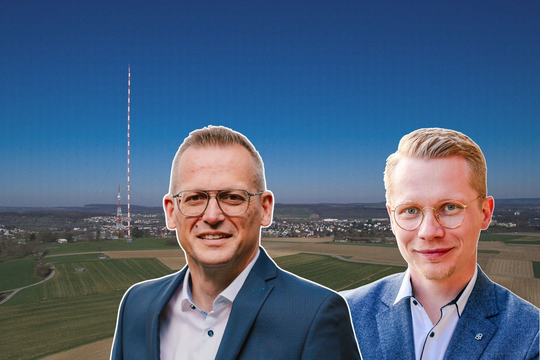 Zwei Männer vor Landschaft mit Sendemast und blauem Himmel.