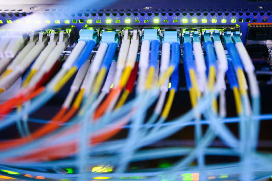 Mehrere bunte Kabel sind in einen Netzwerk-Switch eingesteckt.