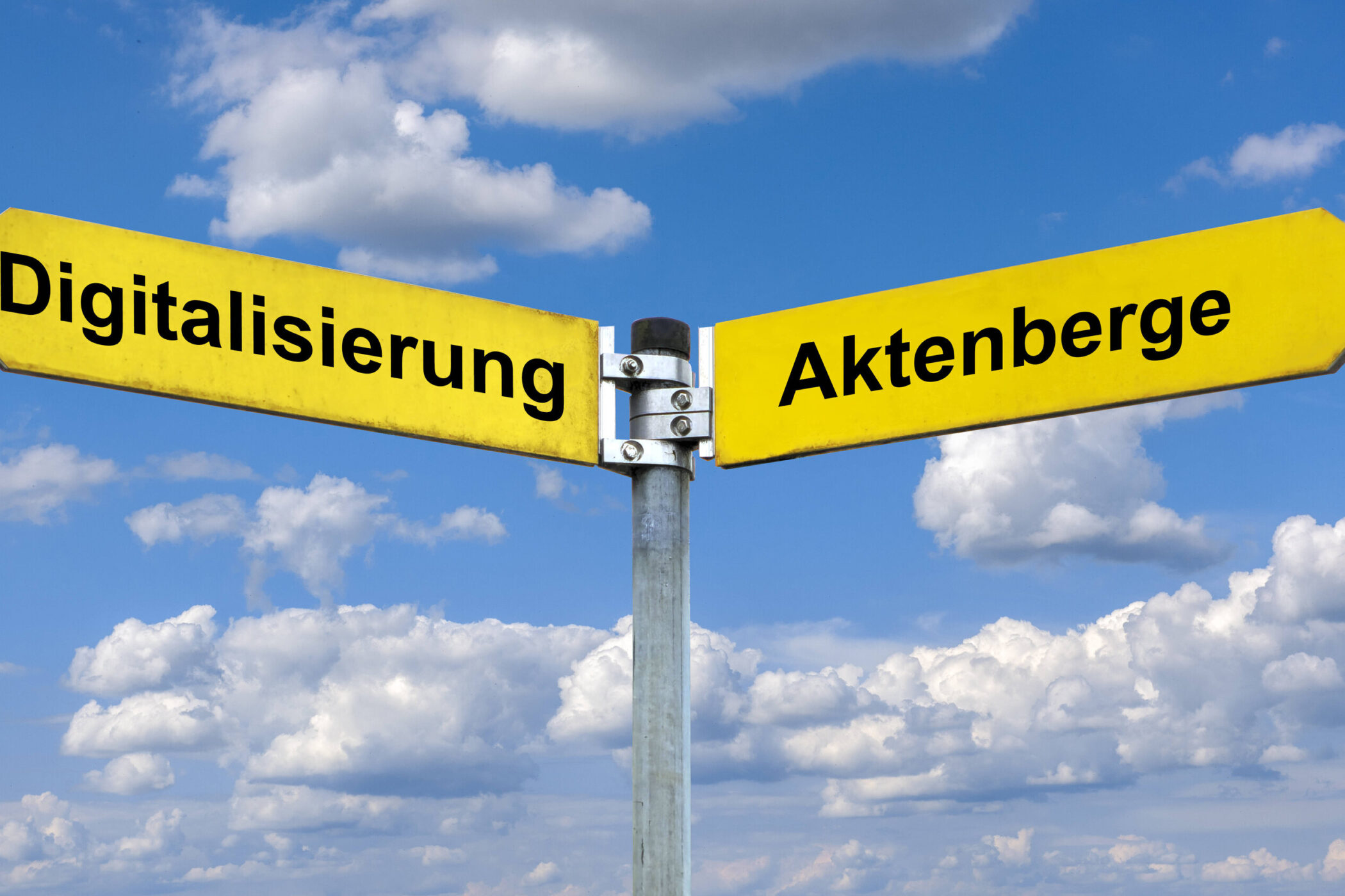 Zwei gelbe Wegweiser mit den Aufschriften "Digitalisierung" und "Aktenberge".