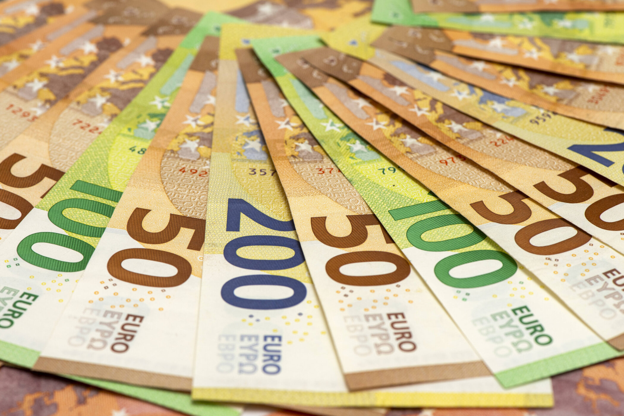 Mehrere Euro-Banknoten in verschiedenen Stückelungen fächerförmig angeordnet.