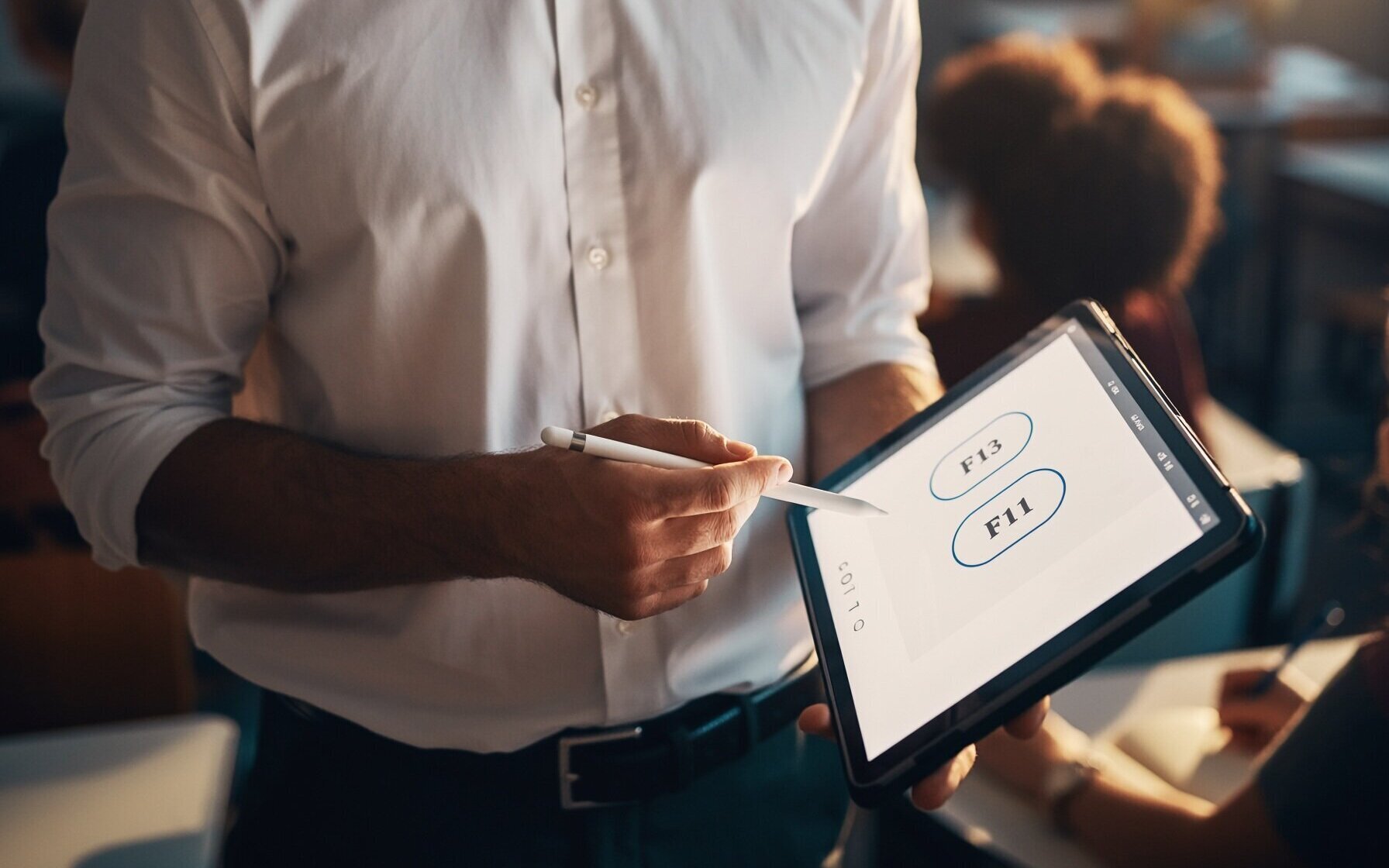 Person hält Tablet mit Stift, zeigt auf Bildschirm mit Tasten F13 und F11.