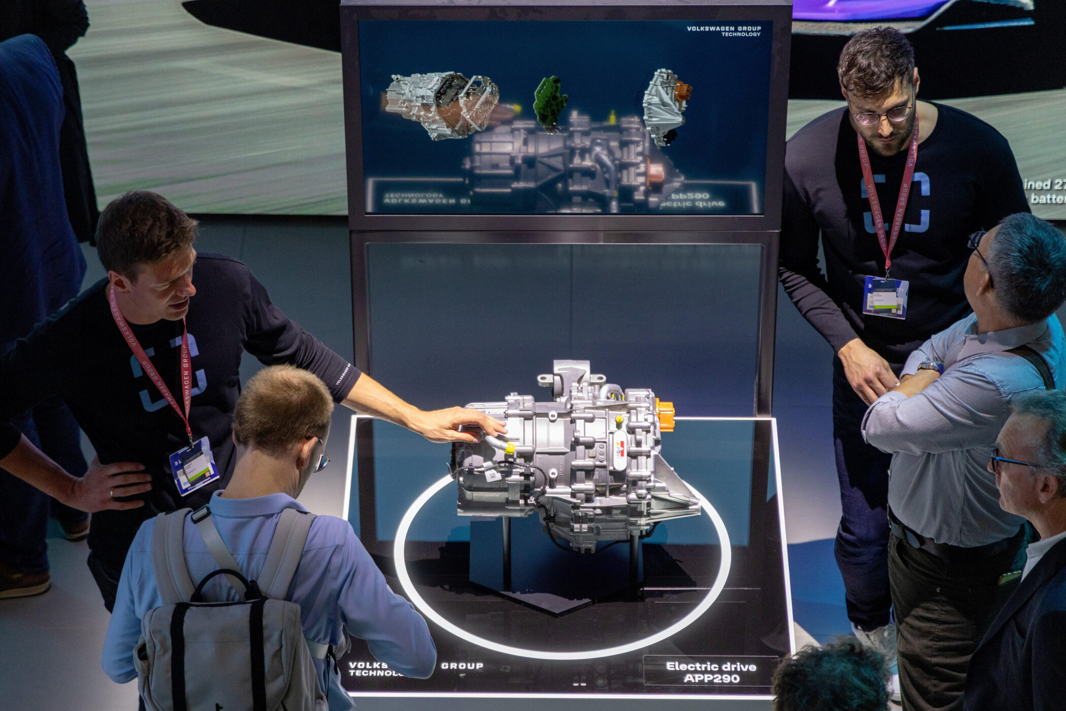 Fünf Personen betrachten ein Modell eines elektrischen Antriebs auf einem Tisch.