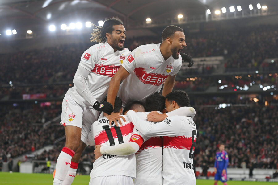 Fußballspieler in weißen Trikots jubeln im Stadion.