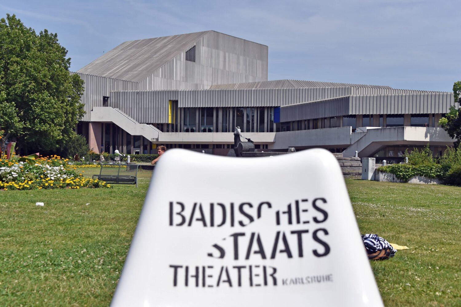 Gebäude mit moderner Architektur, im Vordergrund Text: "BADISCHES STAATSTHEATER".