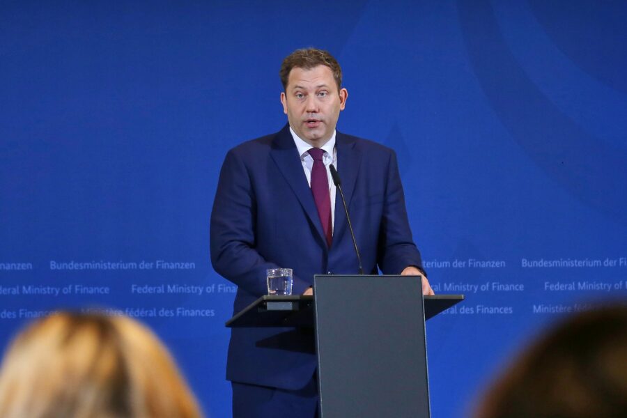 Mann im Anzug spricht am Rednerpult vor blauer Wand mit Text "Bundesministerium der Finanzen".