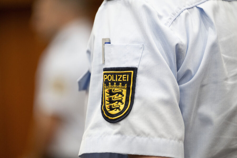 Polizeiuniform mit Abzeichen auf dem Ärmel, Schriftzug "Polizei".