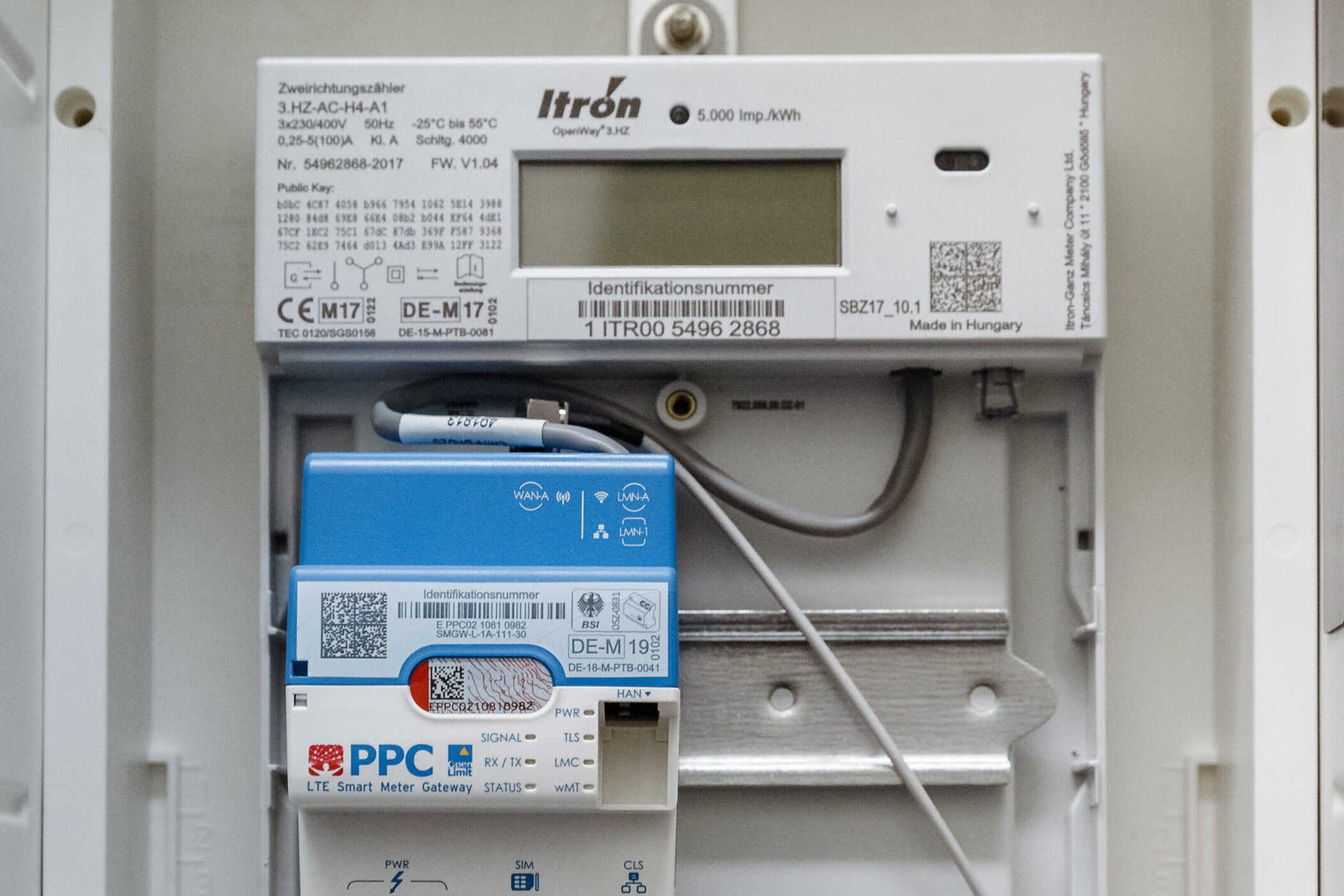 Elektrizitätszähler mit Display und blauer LTE Smart Meter Gateway darunter.