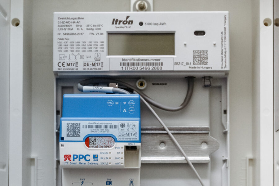 Elektrizitätszähler mit Display und blauer LTE Smart Meter Gateway darunter.