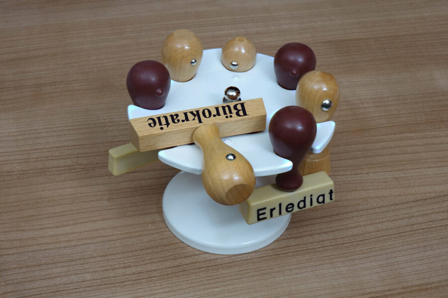 Stempelkarussell mit mehreren Holzstempeln, Aufschrift "Bürokratie" und "Erledigt".