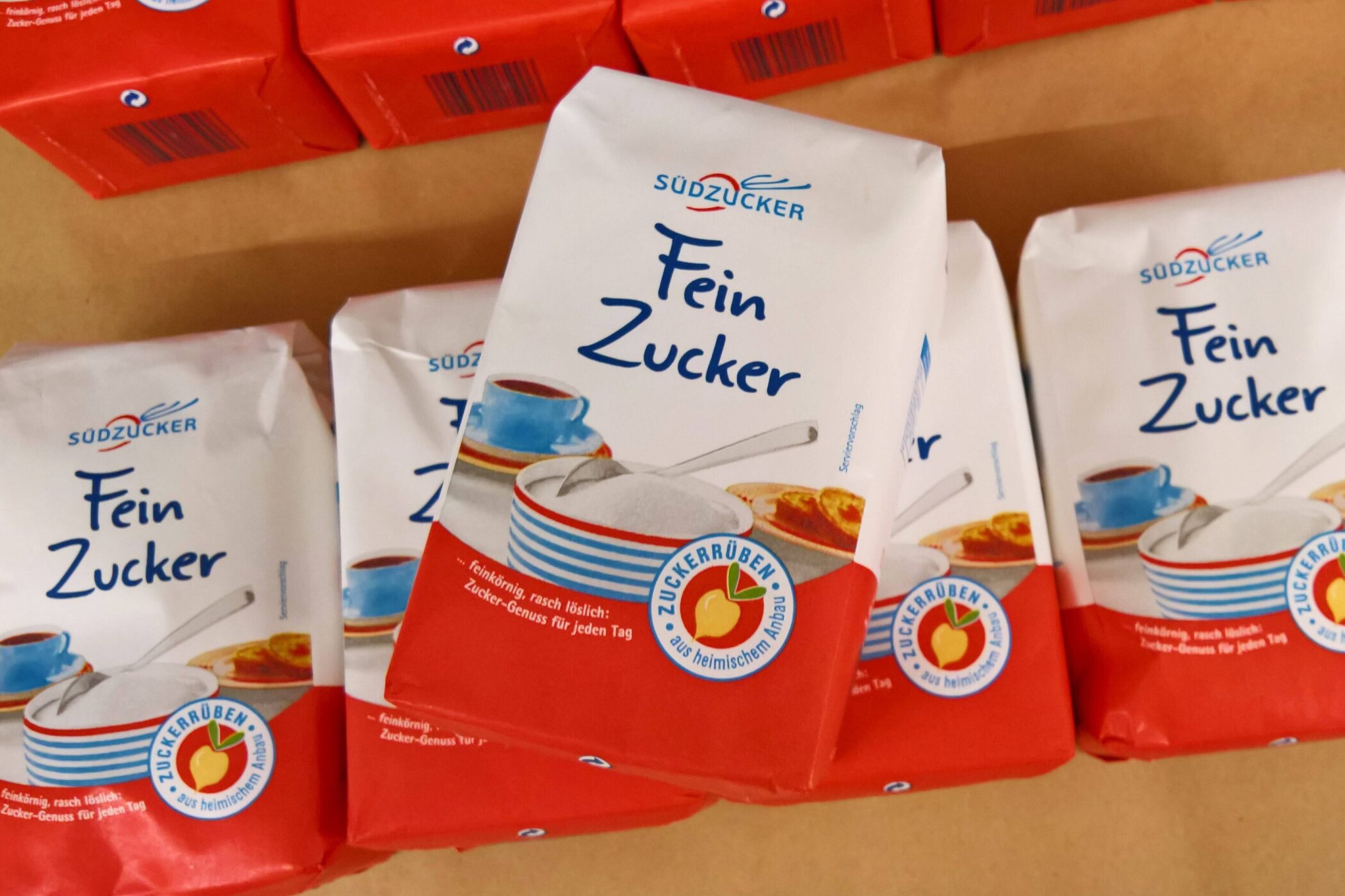 Fünf Packungen Südzucker Fein Zucker auf einem Tisch.