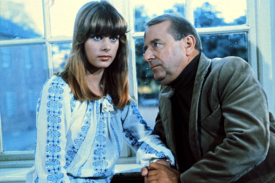 Eine Frau und ein Mann sitzen nebeneinander, der Mann hält ihre Hand.