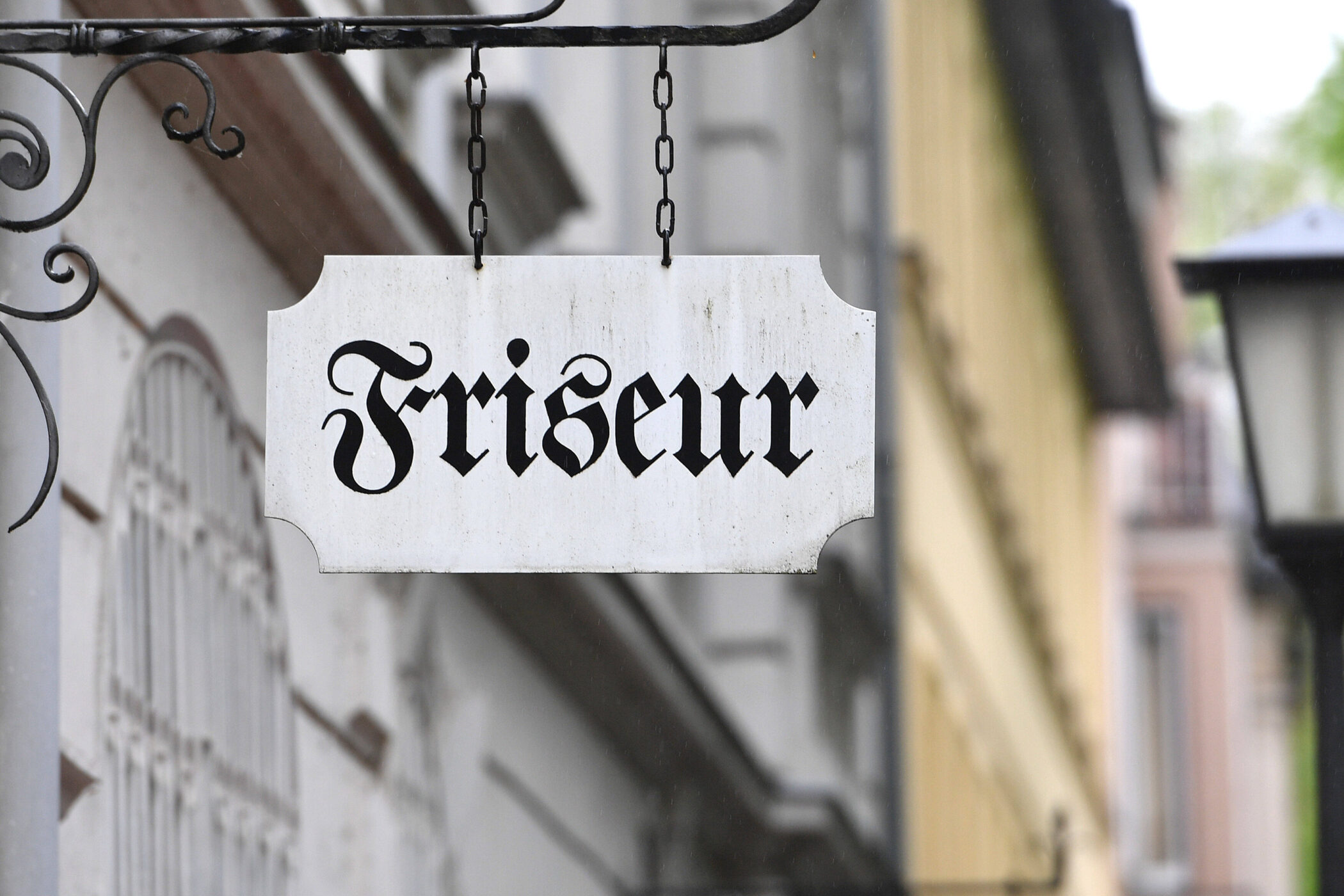 Schild mit der Aufschrift "Friseur" in schwarzer Schrift.