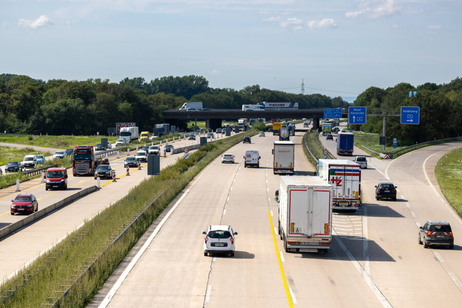Autobahn mit mehreren Fahrspuren, Autos und LKWs, Schilder nach Basel und Heidelberg.