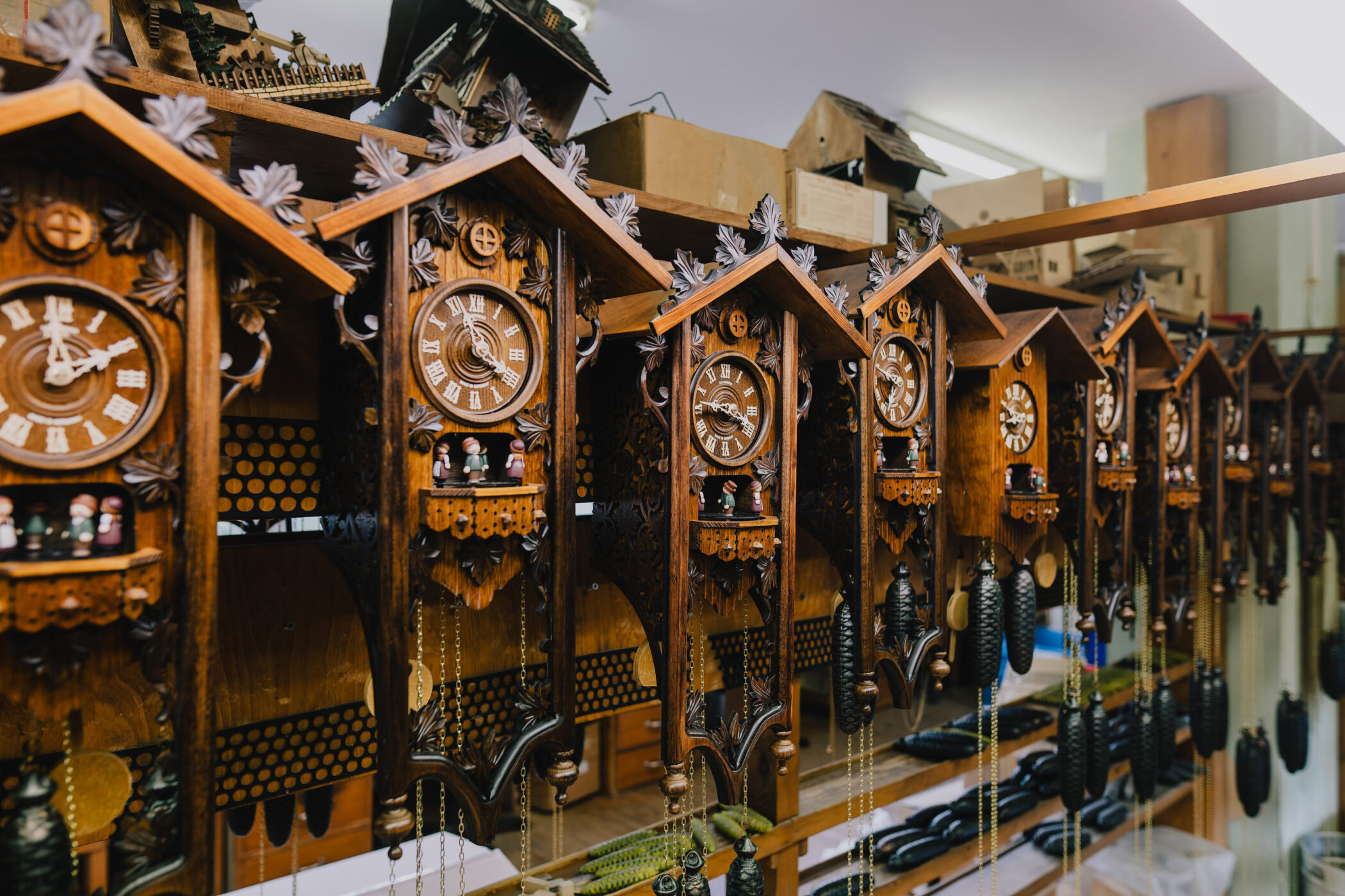Mehrere Kuckucksuhren aus Holz mit römischen Ziffern und Figuren.